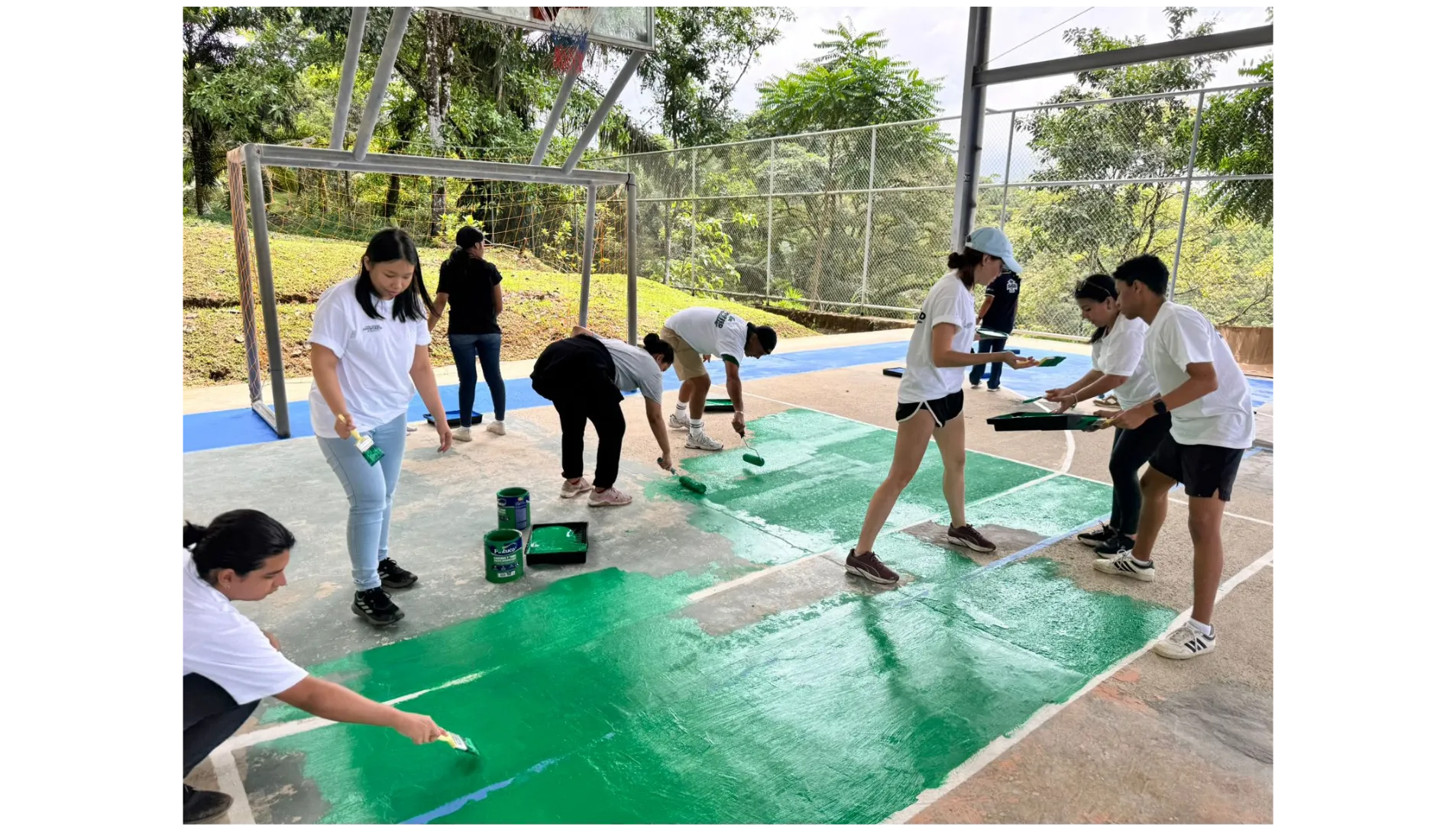 Voluntarios pintando la cancha